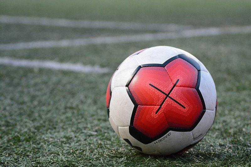 緑のピッチとサッカーボールの実物写真